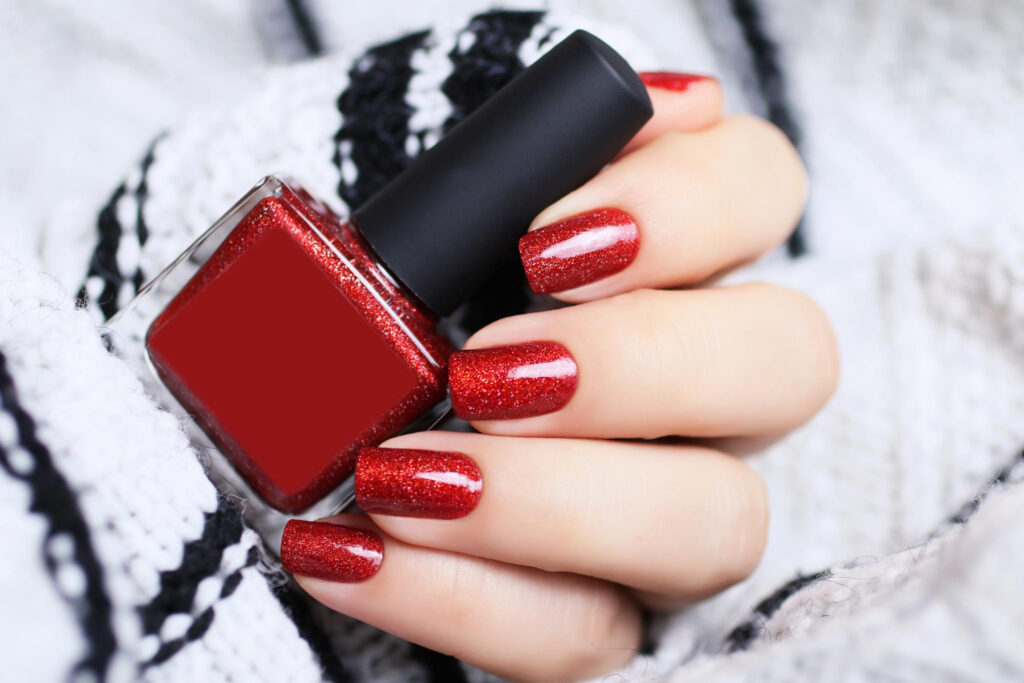 beautiful-female-hand-with-red-manicurein-sweatercozy-atmospherefestive-concept